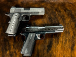 A stainless damascus 1911 next to a carbon damascus 1911