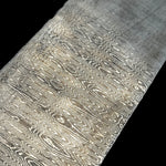 Close-up of Ladder Pattern San Mai featuring a high-performance AEB-L core with AEB-L and 304 stainless Damascus outer layers. The etched ladder pattern shows bold contrast and flowing lines throughout the billet.