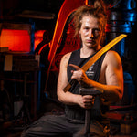 blacksmith for vegas forge named fitz holding a katana sitting in from of nazel hammers