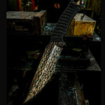 fixed blade sitting on machine made out of copper infused reptilian pattern san mai