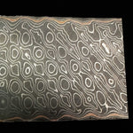 close up picture of a python patterned carbon core san mai damascus with copper layers