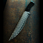 Knife with decorative copperhead san mai blade held by a gloved hand on a dark background