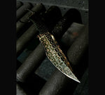 Knife with decorative copperhead san mai blade held by a gloved hand on a dark background