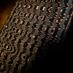 a upright flat bar of copperhead an mai with copper layers flowing around black circles and thin silver lines