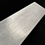 A close-up of chevron like damascus pattern called herringbone shown diagonally against a dark black background.
