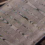 close up picture of a stainless ladder patterned damascus steel billet