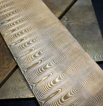 mokume made with layers of bronze and nickel silver laying on top of other mokume billets