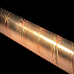 a twisted mokume round bar made iwth layers of copper, brass and nickel-silver