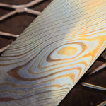 a billet of twisted mokume gane made with layers of copper brass and nickel silver