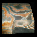 close up on a multi copper san mai billet from vegas forge, made in random pattern