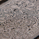 close picture of stainless steel damascus in random pressed pattern by vegas forge