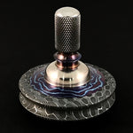 a spinning top made out of stainless reptilian damascus rod