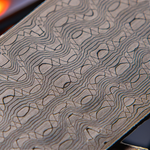 close up image of a stainless reptilian pattern damascus billet
