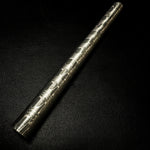 a half inch diameter damascus round bar sitting on a black background