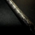a round bar damascus in reverse reptilian pattern on black background

