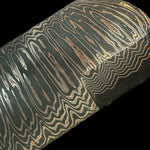 a flat bar of san mai made with layers of copper, carbon steel and nickel with black background