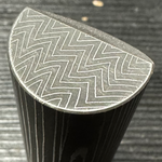 close up on the end of a stainless damascus sharktooth pattern round bar