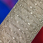 close up image of the flowing circualr lines of spirograph pattern damascus with a blue and red background