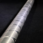 a stainless twist damascus round bar with spiral pattern on black background