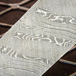 A close-up image of a textured damascus steel with a patterned twist design