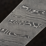 close up image of a twist pattern damascus steel flat bar on blurred grey background