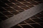 billet of stainless typhoon pattern damascus steel laying on metal table