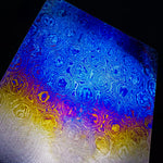 Colorful patterned titanium damascus,also known as timascus, with a gradient from blue to yellow annodized color