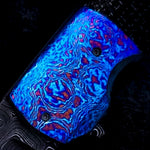 Glowing blue and red patterned titanium damascus bolster on a dark background