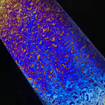 Colorful marbled pattern of titanium damascus, also known as timascus on a black background