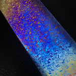 Colorful marbled pattern of titanium damascus, also known as timascus on a black background