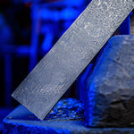 a flat bar of stainless steel virus pattern damascus sitting on power hammer sow block with blue tinted forge in background