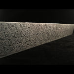 billet of stainless wasphead pattern damascus on black background